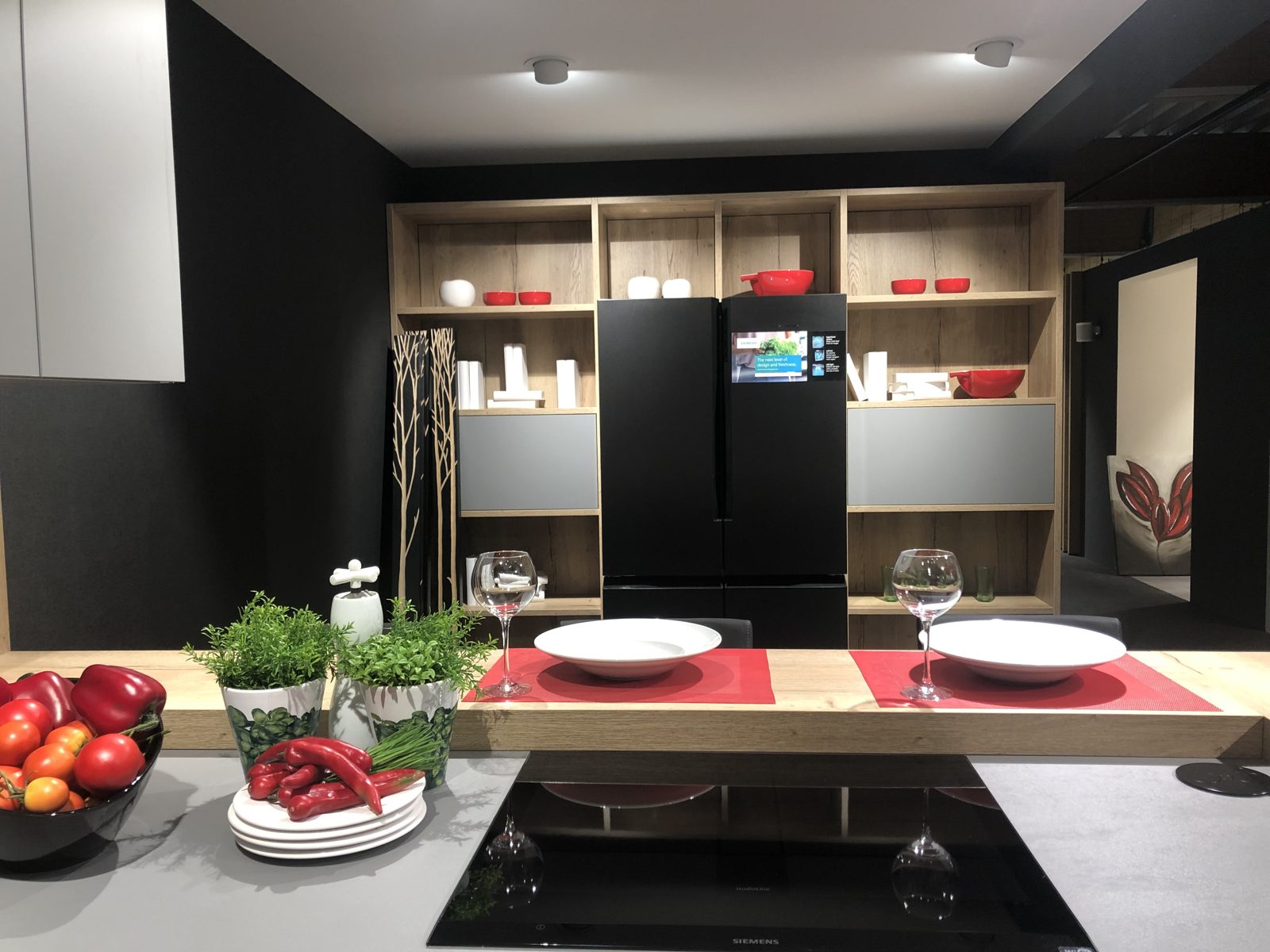 Küche mit Holzregal, roten Schalen, gedeckter Theke und Kräutern